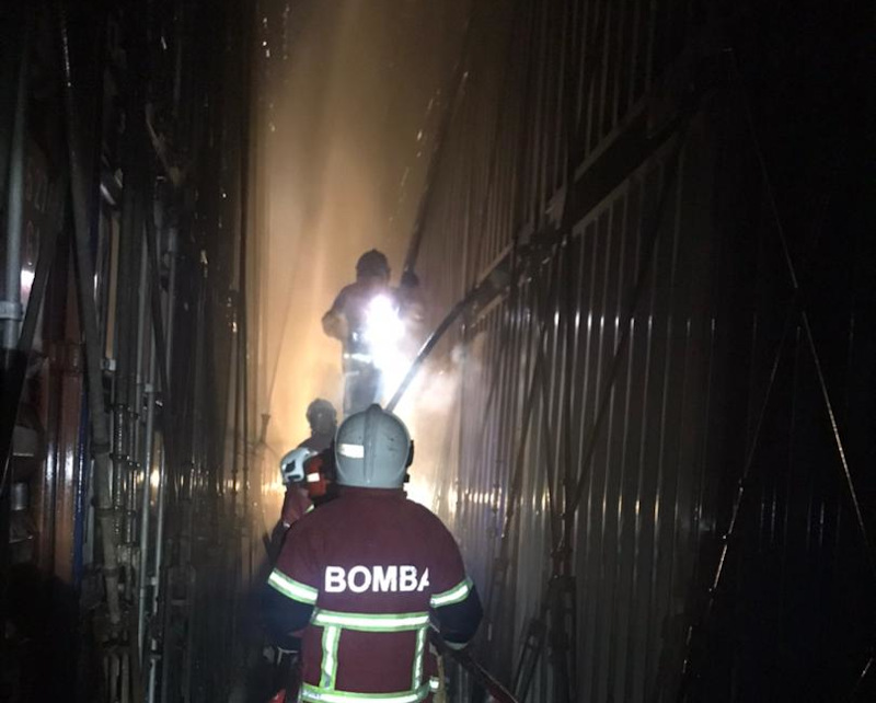 Selangor Fire and Rescue Department personnel in ongoing efforts to put out the fire on 11 industrial goods containers on a cargo vessel in the Pulau Carey waters April 11, 2021. u00e2u20acu201d Picture via Twitter/Bernama