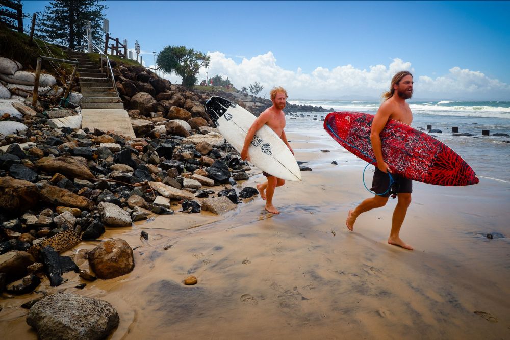 Two surfers negotiate massive beach erosion in the wake of cyclonic conditions at Byron Bay Main Beach. u00e2u20acu201d ETX Studio pic