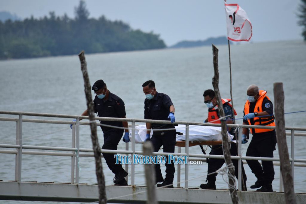 Marine Police personnel carry Chongu00e2u20acu2122s body up the Telaga Air jetty. u00e2u20acu201d Borneo Post Online picnn
