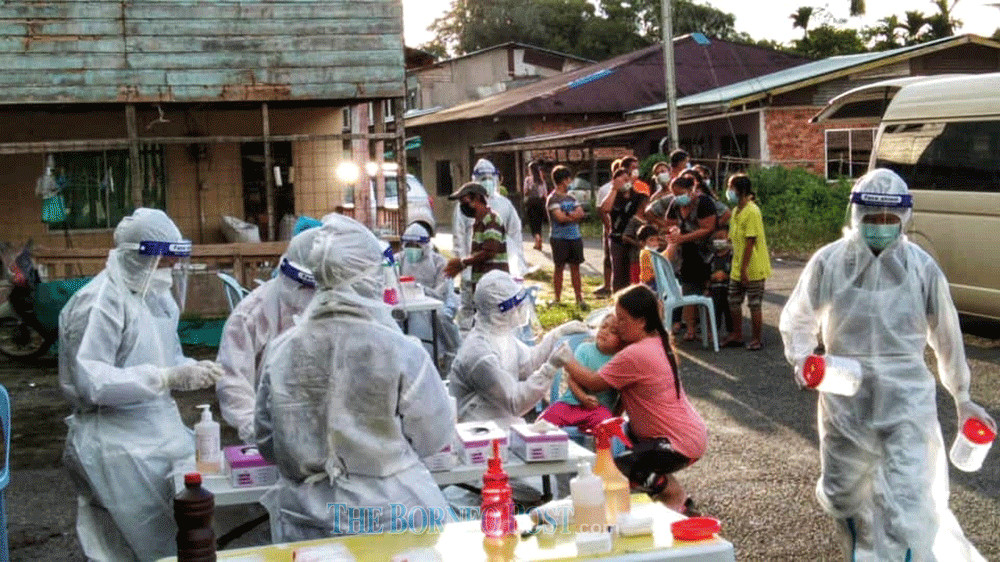 A Covid-19 swab team in the thick of action carrying out sampling at a longhouse in Sibu recently. u00e2u20acu201d Borneo Post Online picnn