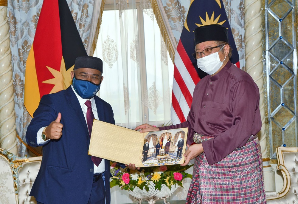 Khairuddin (left) receives a memento from Abang Johari. u00e2u20acu201d Borneo Post Online pic