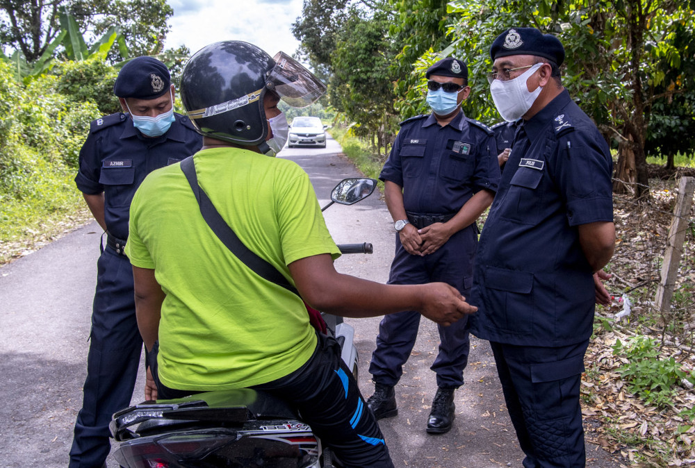 Kelantan police chief Datuk Shafien Mamat quizzes a motorist using a rat trail to neighbouring Terengganu at Jalan Kampung Gong Jenarah Bukit Yong, April 23, 2021. u00e2u20acu201d Bernama pic 