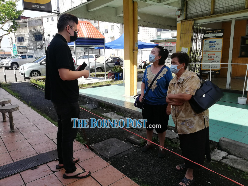 Dr Yii speaks to two senior citizens about the vaccination programme. u00e2u20acu201d Borneo Post Online pic