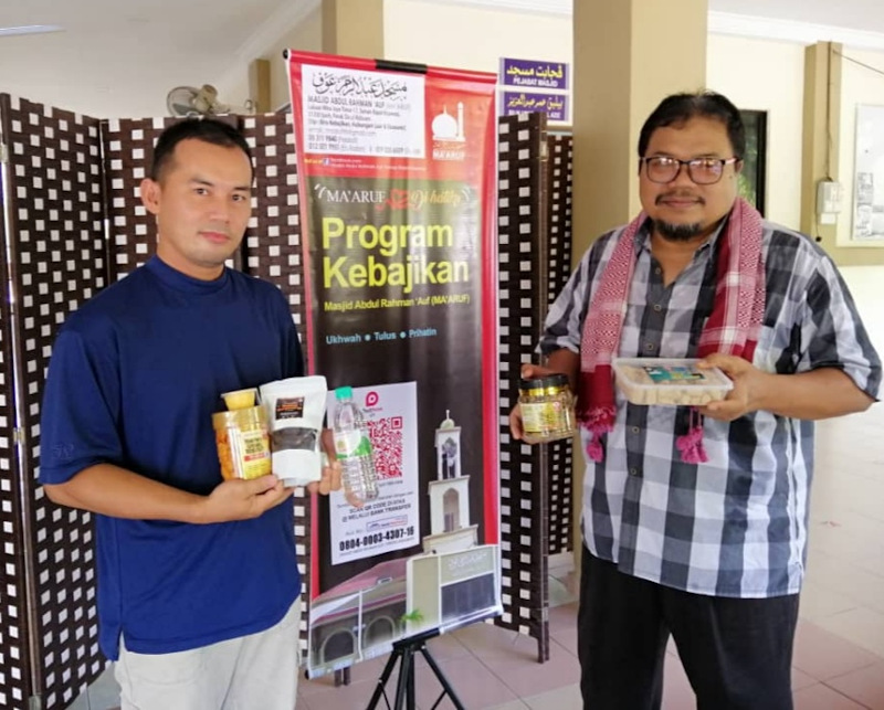 Masjid Abdul Rahman ‘Auf’s committee member Muhamad Akhyar Asnawi (right) and assistant secretary Mohd Yazid Soib with the food items sold at the mosque on Fridays as part of their fund raising activity. — Picture by Sylvia Looi 