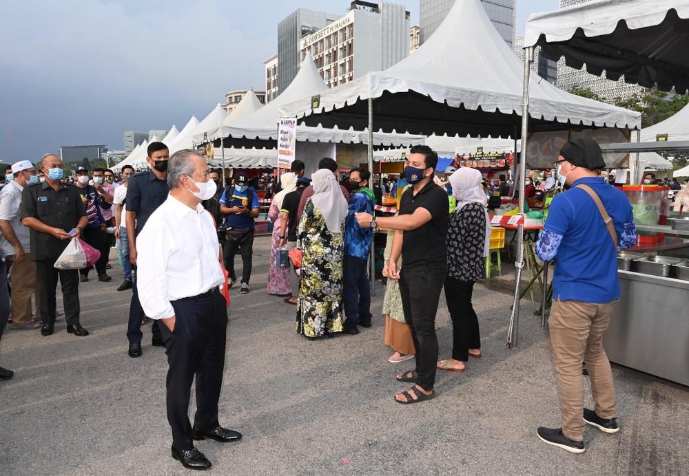 Prime Minister Tan Sri Muhyiddin Yassin chats with visitors during his visit to the Precinct 3 Ramadan Bazaar in Putrajaya, April 14, 2021. u00e2u20acu201d Bernama pic 