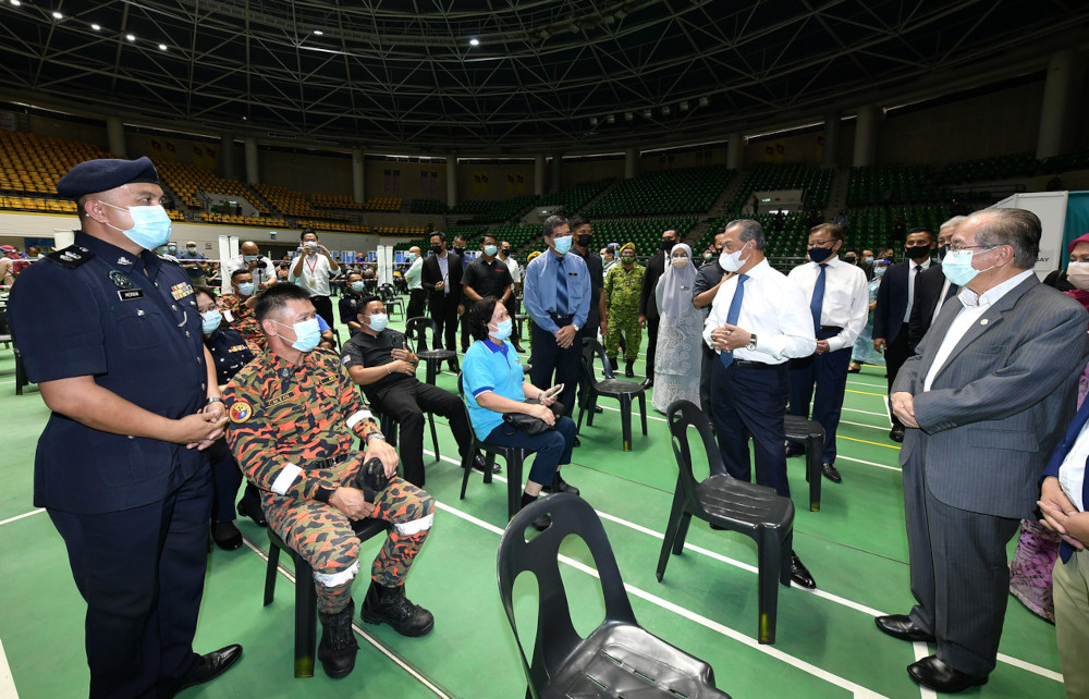 Prime Minister Tan Sri Muhyiddin Yassin visits the Covid-19 vaccination centre at Stadium Perpaduan in Petra Jaya, Sarawak, April 1, 2021. With him is Sarawak Deputy Chief Minister Datuk Amar Douglas Uggah Embas. u00e2u20acu201d Bernama pic 