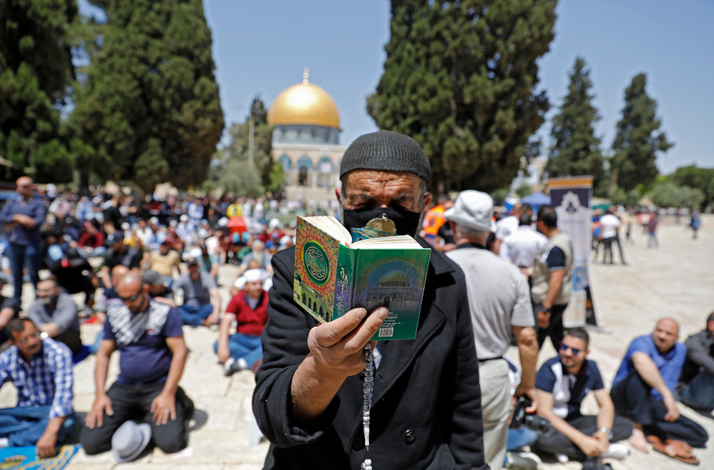 A man reads the Quran as Palestinians gather during the second Friday prayers of the Muslim fasting month of Ramadan, outside the Dome of the Rock at the Al-Aqsa Mosque compound, in Jerusalemu00e2u20acu2122s Old City, April 23, 2021. u00e2u20acu201d AFP pic 