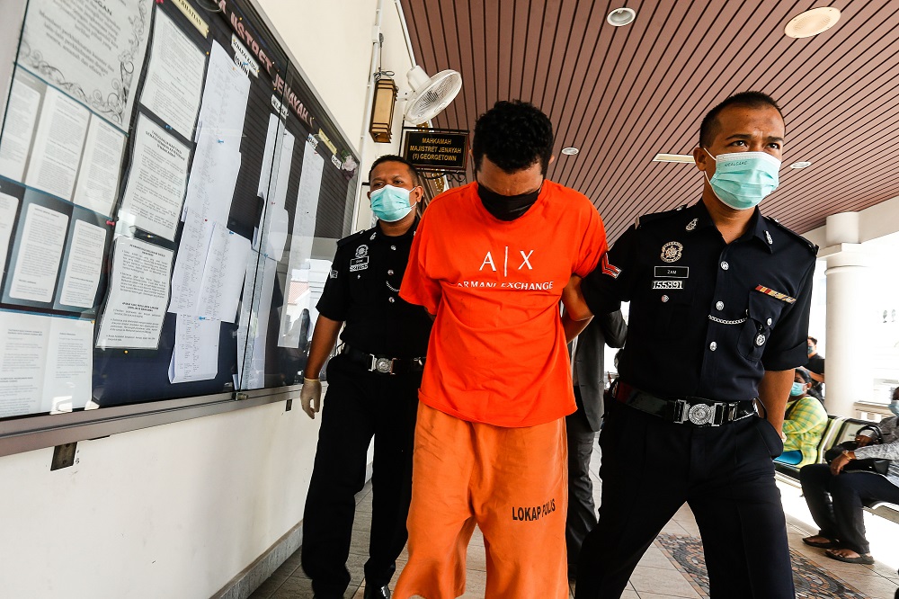 Mohd Arafat Taufik is escorted by policemen at the Magistrateu00e2u20acu2122s Court in George Town April 23, 2021. u00e2u20acu2022 Picture by Sayuti Zainudin