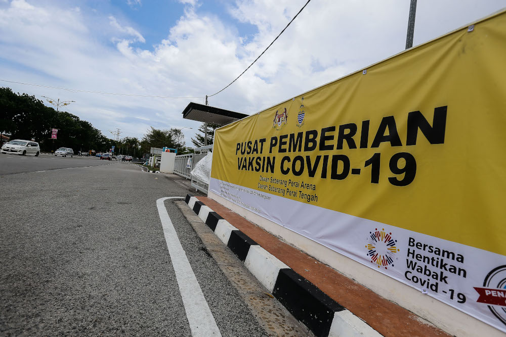 A motorist rides past the Vaccine Administration Centre banner in Seberang Perai Arena, Seberang Jaya April 2, 2021. — Picture by Sayuti Zainudin