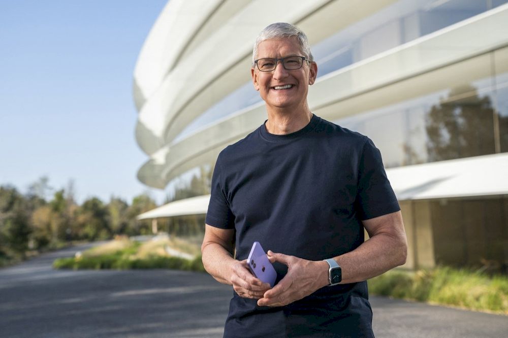 This handout released and taken on April 20, 2021 by Apple inc. shows Apple CEO Tim Cook holding a new purple iPhone 12 during a special event at Apple Park in Cupertino, California. u00e2u20acu201d AFP pic