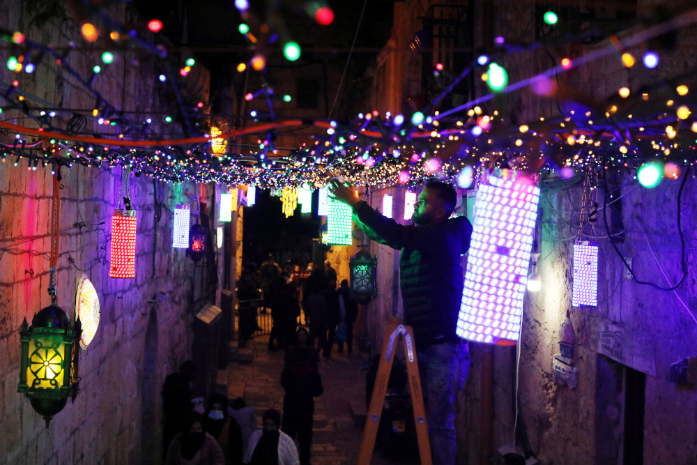 A man sets lights for decoration in an alley in Jerusalemu00e2u20acu2122s Old City as part of the preparation for the holy Muslim month of Ramadan as Covid-19 restrictions ease around the country April 11, 2021. u00e2u20acu201d Reuters pic