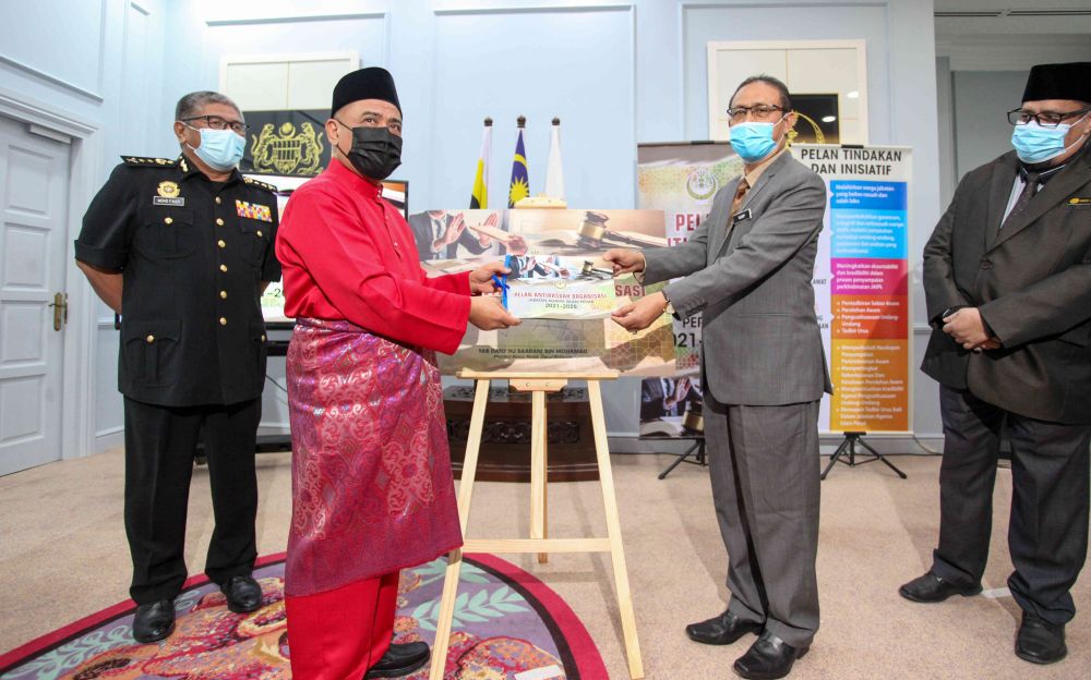 Perak Islamic Religious Department director Datuk Mohd Yusof Husin (second from right) hands the departmentu00e2u20acu2122s anti-corruption action plan over to Saarani at the Mentri Besar's Office in Ipoh April 28, 2021. u00e2u20acu201d Picture by Farhan Najib