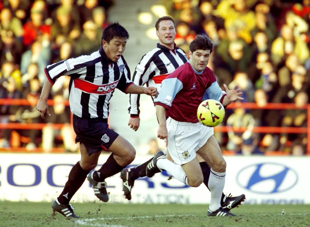 Burnley's Andy Payton is challenged by Grimsby's Zhang Enhua (right) February 17, 2001. u00e2u20acu201d Reuters pic
