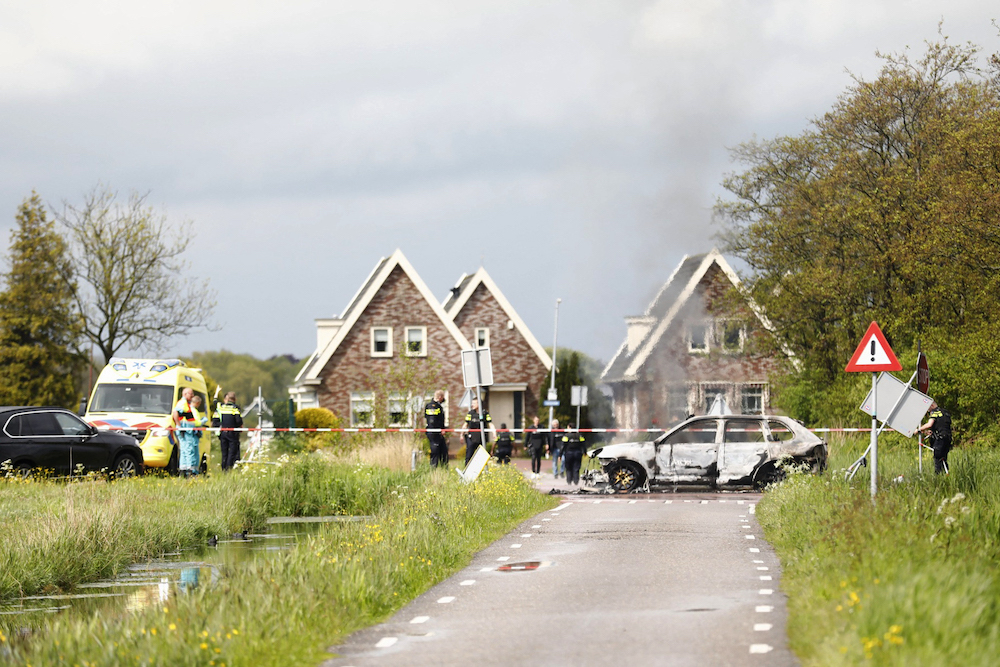 Emergency services stand near a burnt car in Broek in Waterland, on May 19, 2021. u00e2u20acu201d AFP pic