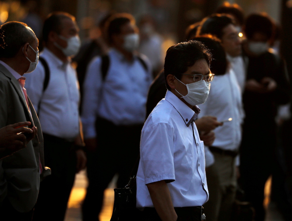 Office workers wearing protective face masks walk to head home at sunset amid the Covid-19 outbreak, in Tokyo, Japan June 9, 2020. u00e2u20acu201d Reuters pic