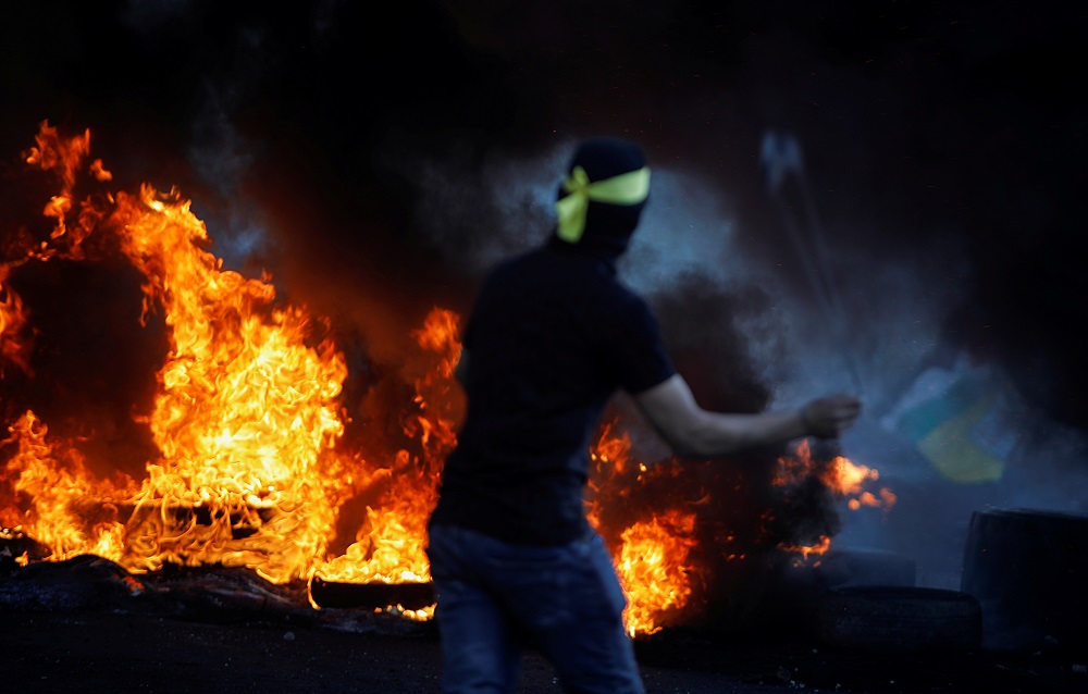 A Palestinian uses a sligshot during an anti-Israel protest over a cross-border violence between Palestinians in Gaza and the Israeli military, near Hawara checkpoint near Nablus in the Israeli-occupied West Bank May 18, 2021. u00e2u20acu201d Reuters pic