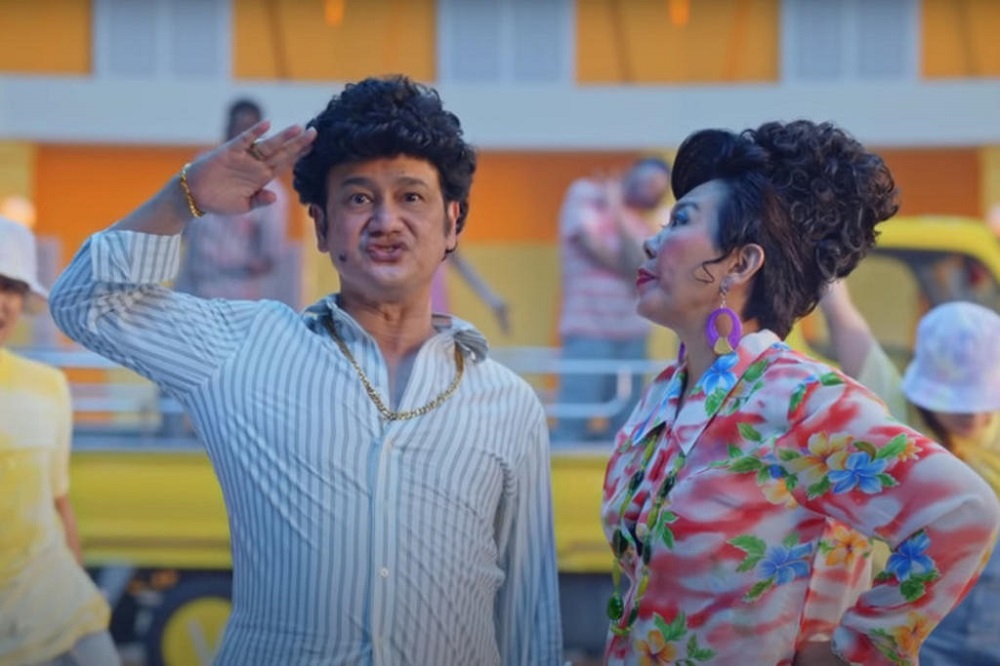 Gurmit Singh, playing Phua Chu Kang, and Irene Ang, playing his wife Rosie, in the public service video on Covid-19 vaccination entitled Get Your Shot, Steady Pom Pi Pi. u00e2u20acu201d Screen capture via YouTube/Govsg