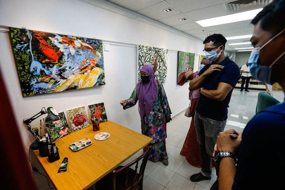 The family of the late Nasir Nadzir view some of the painting made by Nasir during the exhibition held at The Art Gallery, Pulau Tikus May 7, 2021. — Picture by Sayuti Zainudin