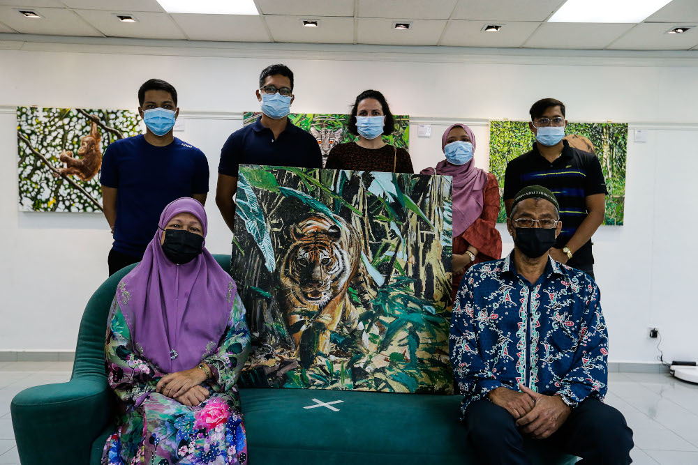 The family of late Nasir Nadzir pose with the last incomplete painting made by Nasir during the exhibition held at The Art Gallery, Pulau Tikus May 7, 2021. — Picture by Sayuti Zainudin