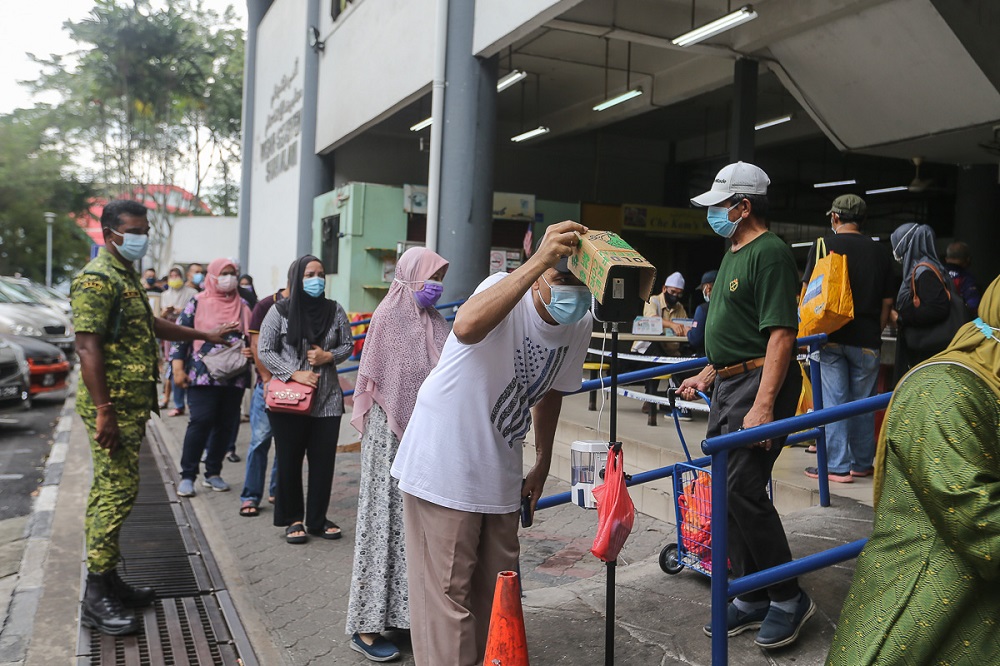 People have their temperature checked before entering the Seksyen 6 wet market in Shah Alam May 11, 2021. u00e2u20acu201d Picture by Yusof Mat Isa