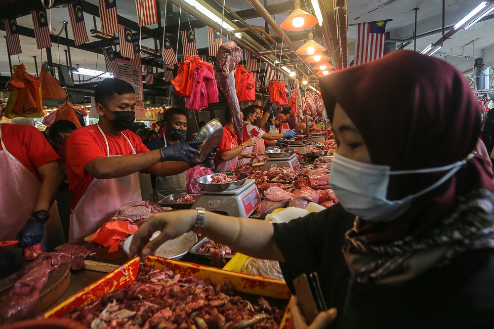 A customer buys fresh meat from a butcher stall at the Seksyen 6 wet market in Shah Alam May 11, 2021. u00e2u20acu201d Picture by Yusof Mat Isa
