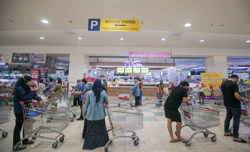Customers queuing up with the trollies at the Aeon Kinta City supermarket in Ipoh to stock up their supplies as government announced enhanced movement control order (EMCO) May 21, 2021. u00e2u20acu201d Picture by Farhan Najib