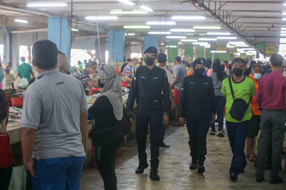 Police personnel making rounds at the Pasar Besar Ipoh to make sure the public follows the Covid-19 SOP while shopping as government announced the EMCO in Ipoh May 21, 2021. — Picture by Farhan Najib
