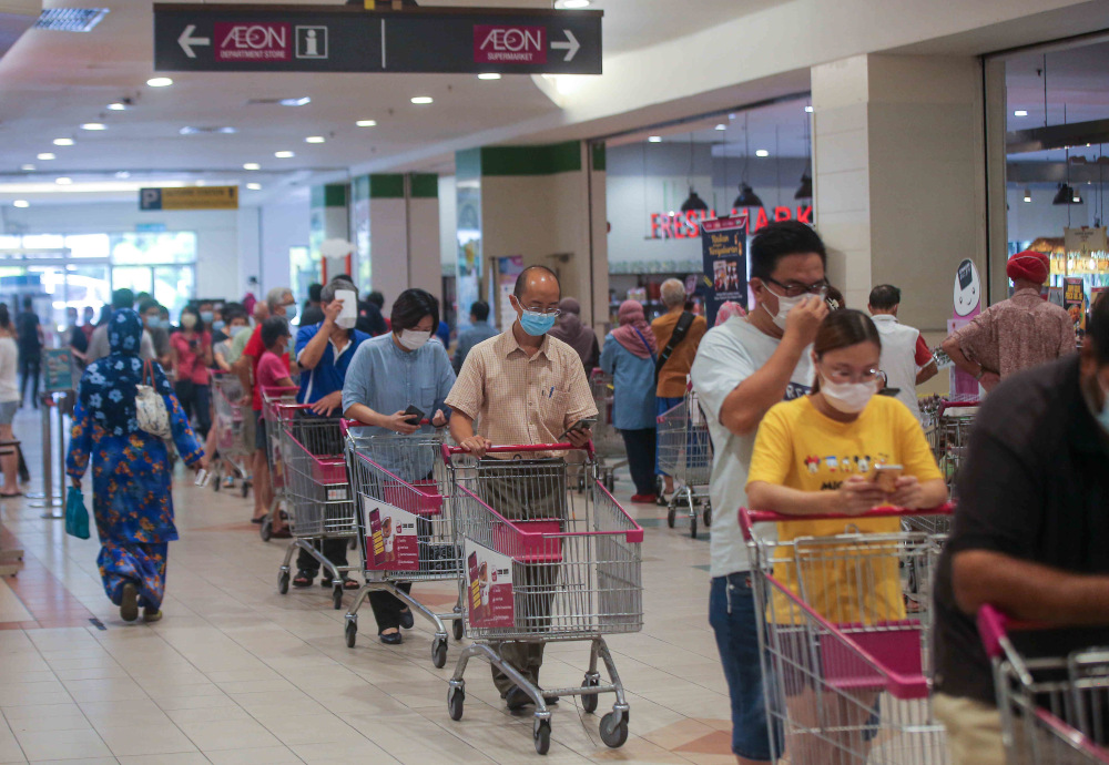Customers queuing up with the trollies at the Aeon Kinta City supermarket in Ipoh to stock up their supplies as government announced enhanced movement control order (EMCO) May 21, 2021. — Picture by Farhan Najib