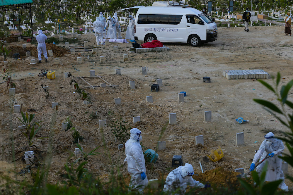 Covid 19 victims body arrive for funeral service handled by health workers equiped with personal protective suit at Kampung Sungai Pusu muslim cemetery. May 22,2021. u00e2u20acu201d Picture by Ahmad Zamzahurinnn