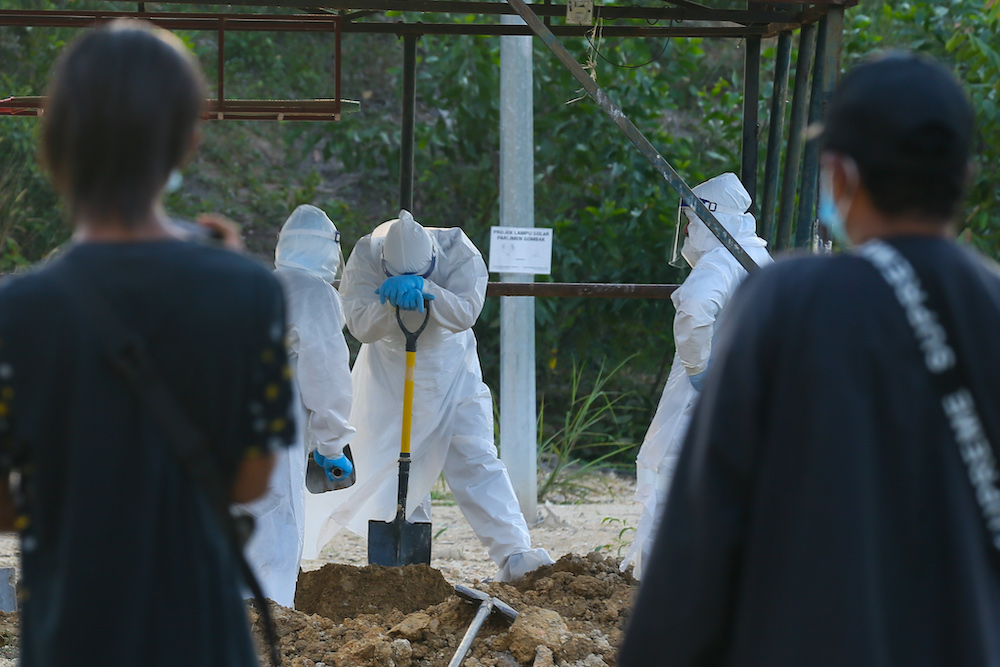 Covid 19 victims body arrive for funeral service handled by health workers equiped with personal protective suit at Kampung Sungai Pusu muslim cemetery. May 22,2021. u00e2u20acu201d Picture by Ahmad Zamzahurinnn