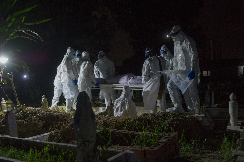 Health workers in personal protective equipment prepare to bury the body of a Covid-19 victim at the Muslim cemetery in Kampung Changkat Gombak, Kuala Lumpur May 30, 2021. u00e2u20acu201dPicture by Shafwan Zaidonn