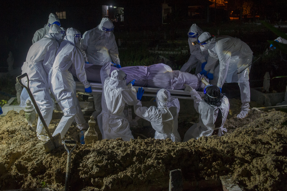 Health workers in personal protective equipment prepare to bury the body of a Covid-19 victim at the Muslim cemetery in Kampung Changkat Gombak, Kuala Lumpur May 30, 2021. u00e2u20acu201dPicture by Shafwan Zaidonn