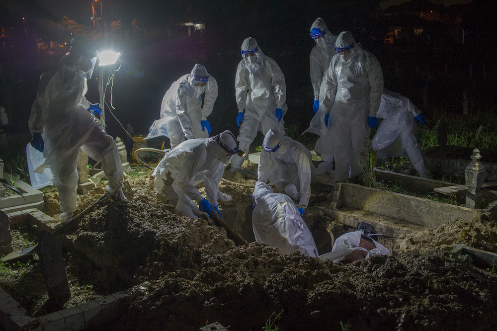 Health workers in personal protective equipment prepare to bury the body of a Covid-19 victim at the Muslim cemetery in Kampung Changkat Gombak, Kuala Lumpur May 30, 2021. u00e2u20acu201dPicture by Shafwan Zaidonn