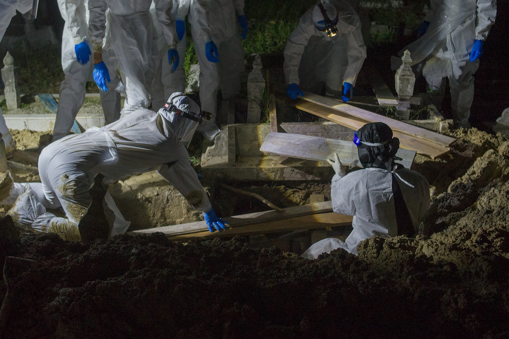 Health workers in personal protective equipment prepare to bury the body of a Covid-19 victim at the Muslim cemetery in Kampung Changkat Gombak, Kuala Lumpur May 30, 2021. u00e2u20acu201dPicture by Shafwan Zaidonn
