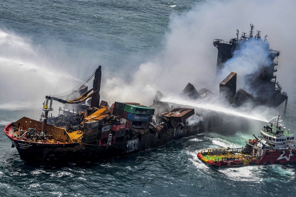Smoke billows from the Singapore-registered container ship MV X-Press Pearl as vessels try to douse off the fire, in the sea off Sri Lankau00e2u20acu2122s Colombo Harbour, in Colombo May 30, 2021. u00e2u20acu201d Picture courtesy of Sri Lanka Air Force via AFP 