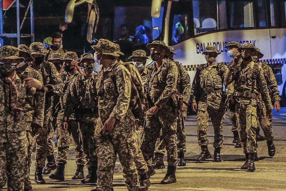 Members of the Malaysian Armed Forces (ATM) are seen installing barbed wire around at Kampung Limau People's Housing Project (PPR) area in Kuala Lumpur following the enhanced movement control order (EMCO) from May 23 to June 5. u00e2u20acu201d Picture by Hari Anggara