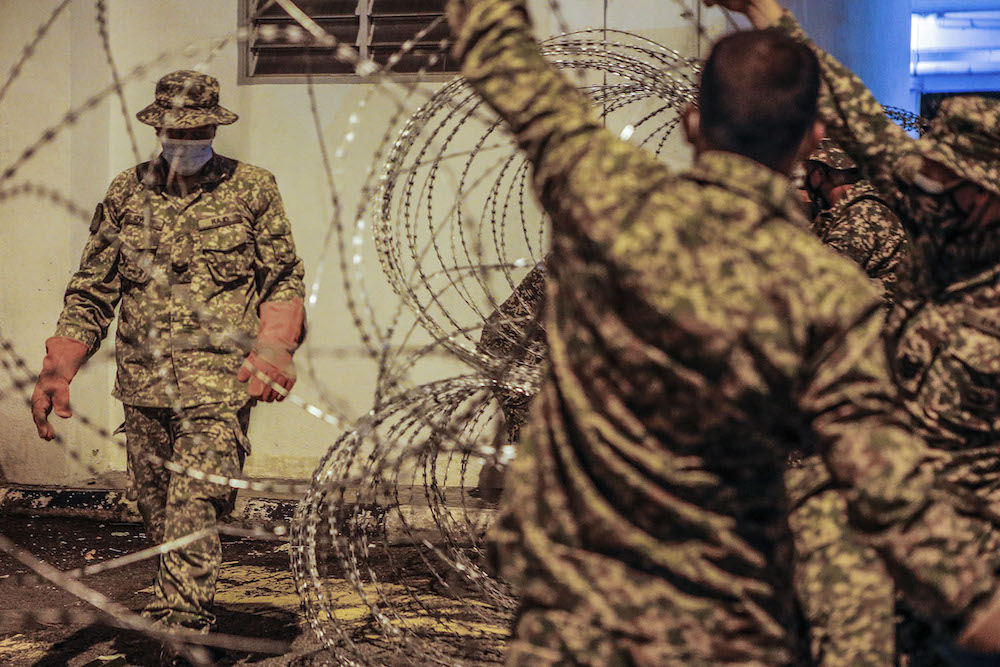 Members of the Malaysian Armed Forces (ATM) are seen installing barbed wire around at Kampung Limau People's Housing Project (PPR) area in Kuala Lumpur following the enhanced movement control order (EMCO) from May 23 to June 5. u00e2u20acu201d Picture by Hari Anggara