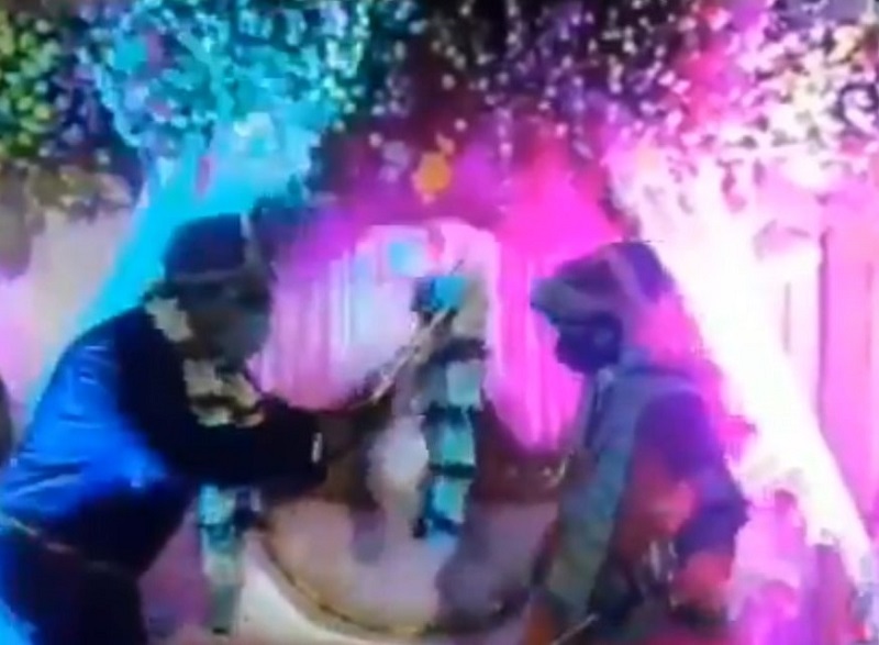 Bride and groom using bamboo sticks to exchange their wedding garlands. u00e2u20acu2022 Screengrab by Twitter/DipanshuKabra