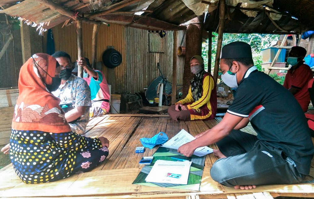 Villager Syaimi Hek @ Ab Hadi (right) assists the Orang Asli from the Batek tribe fill up forms to register for the Covid-19 vaccination in Gua Musang, May 29, 2021. u00e2u20acu201d Bernama pic