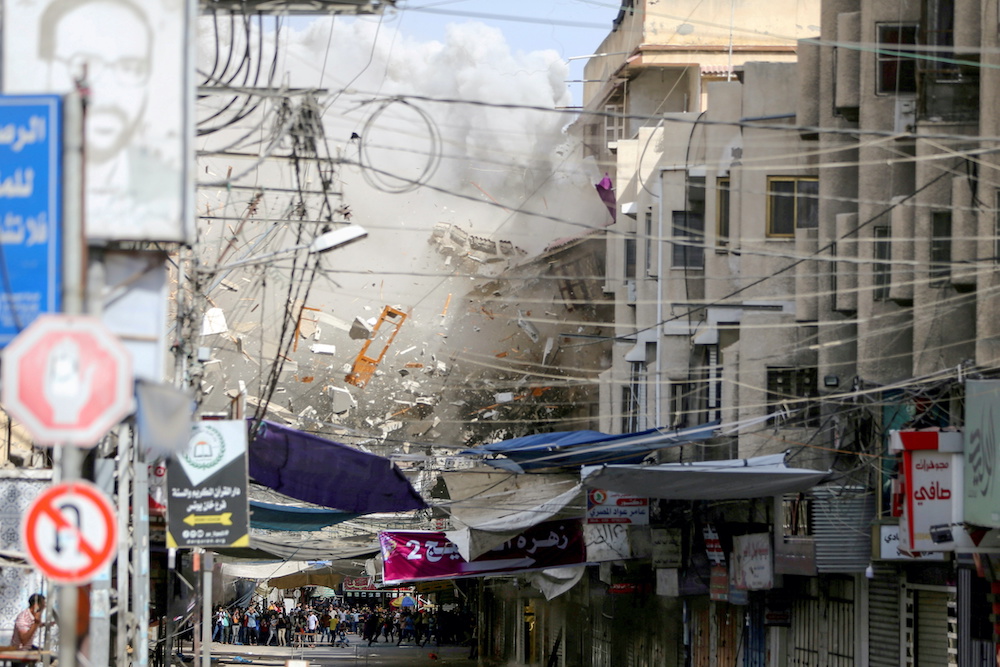 Debris fly as smoke rises following an Israeli air strike, amid Israeli-Palestinian fighting, in Khan Younis in the southern Gaza Strip, May 20, 2021. u00e2u20acu201d Reuters picnn