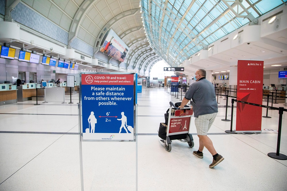 A man pushes a baggage cart wearing a mandatory face mask as a u00e2u20acu02dcHealthy Airportu00e2u20acu2122 initiative is launched for travel, to slow the spread of Covid-19 at Toronto Pearson International Airport in Toronto, Ontario, Canada June 23, 2020. u00e2u20acu2022 Reuters file pic