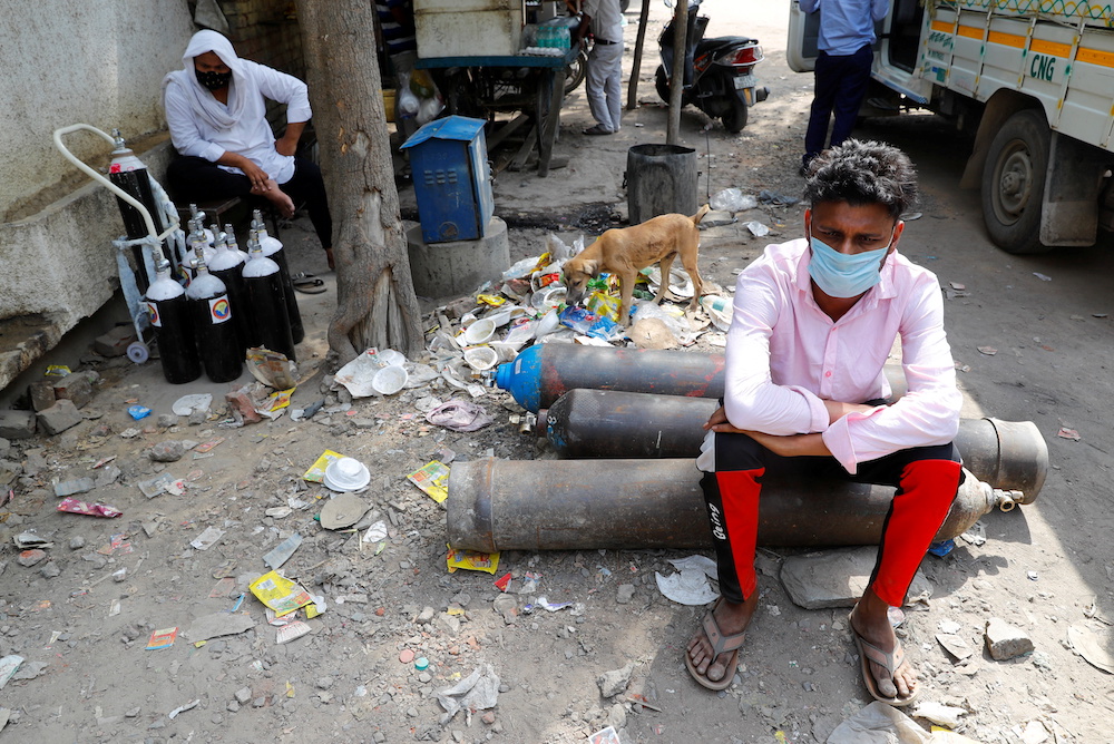 Sumit Kumar, 28, sits on an oxygen cylinder as he waits outside a factory to get it refilled, amidst the spread of the coronavirus disease in New Delhi, India, April 28, 2021. u00e2u20acu201d Reuters pic