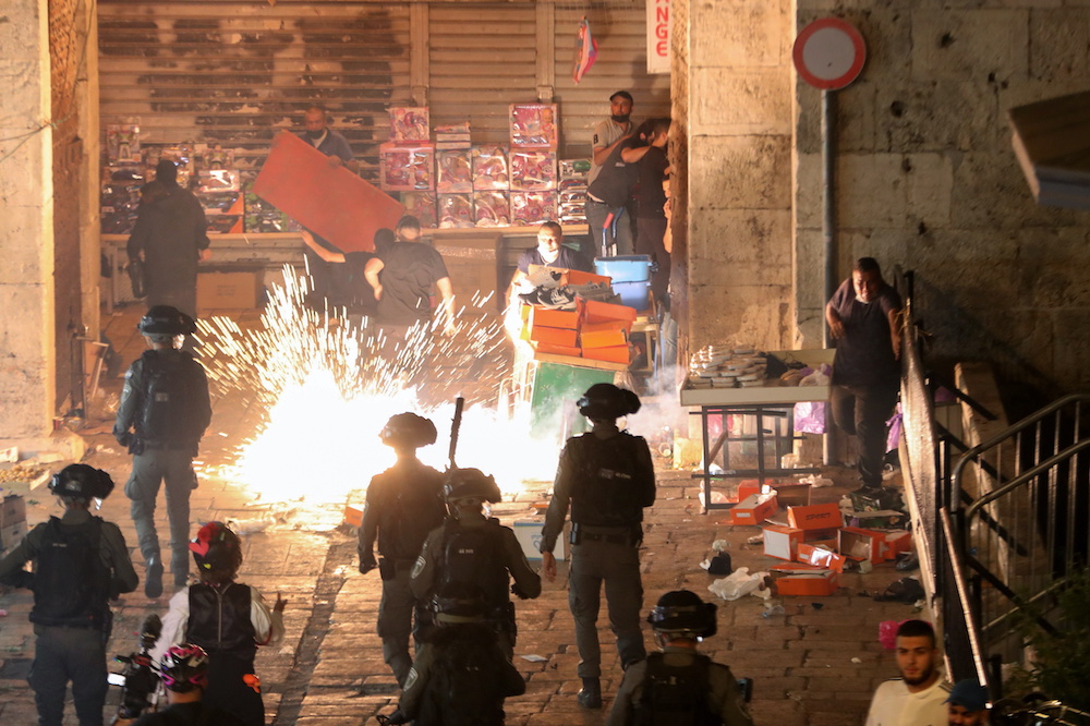 Palestinians react as Israeli police fire a stun grenade during clashes at Damascus Gate on Laylat al-Qadr during the holy month of Ramadan, in Jerusalemu00e2u20acu2122s Old City, May 9, 2021. u00e2u20acu2022 Reuters pic