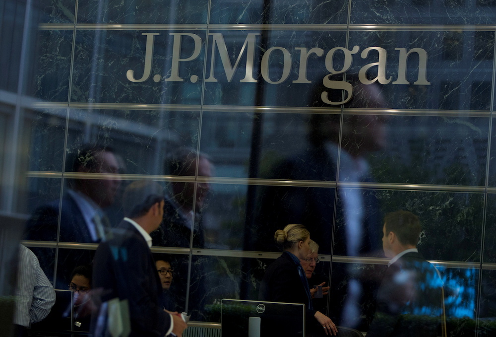 Workers are reflected in the windows of the Canary Wharf offices of JP Morgan in London September 19, 2013. u00e2u20acu2022 AFP