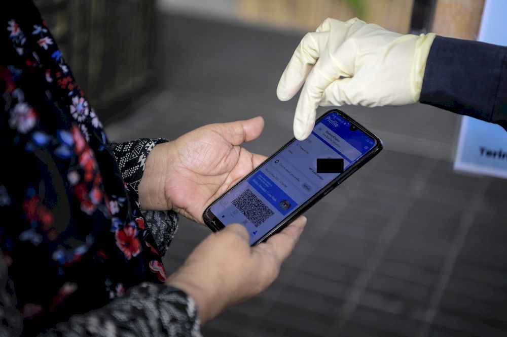 A policeman checking the use of the MySejahtera application at a shopping mall after the enforcement of the Standard Operating Procedures (SOP) of the Movement Control Order (PKP) 3.0, May 25, 2021. u00e2u20acu201d Bernama pic