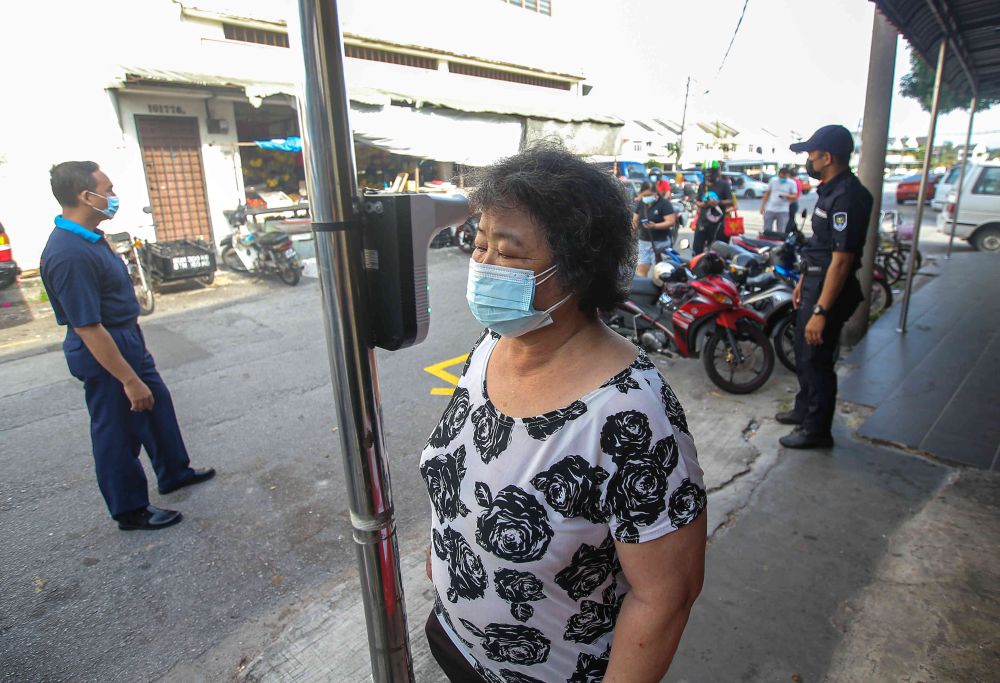 A woman has her temperature checked before entering Pasar Besar Gunung Rapat in Ipoh May 24, 2021. u00e2u20acu201d Picture by Farhan Najib