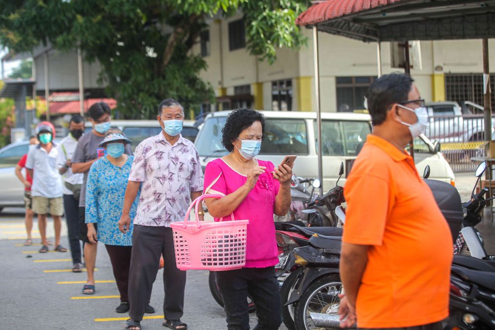 People observe social distancing as they wait to enter Pasar Besar Gunung Rapat in Ipoh May 24, 2021. u00e2u20acu201d Picture by Farhan Najib