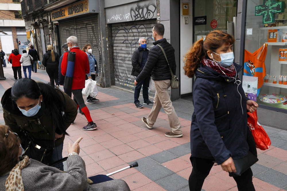 People stand next to closed-down businesses as they wait to enter a pharmacy, amid the Covid-19 pandemic, in Madrid March 12, 2021. u00e2u20acu2022 Reuters file pic