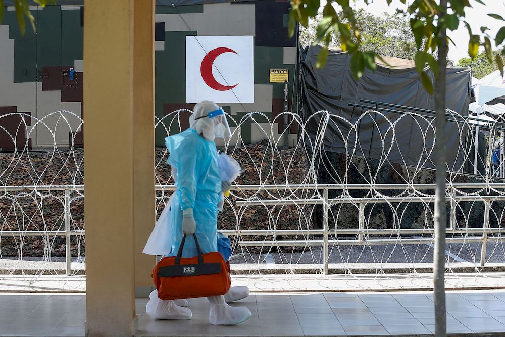 Medical personnel donning PPEs walk beside the barbed wire barrier near the Field Intensive Care Unit (ICU) at Kepala Batas Hospital on April 24, 2021. u00e2u20acu201d Picture by Sayuti Zainudin