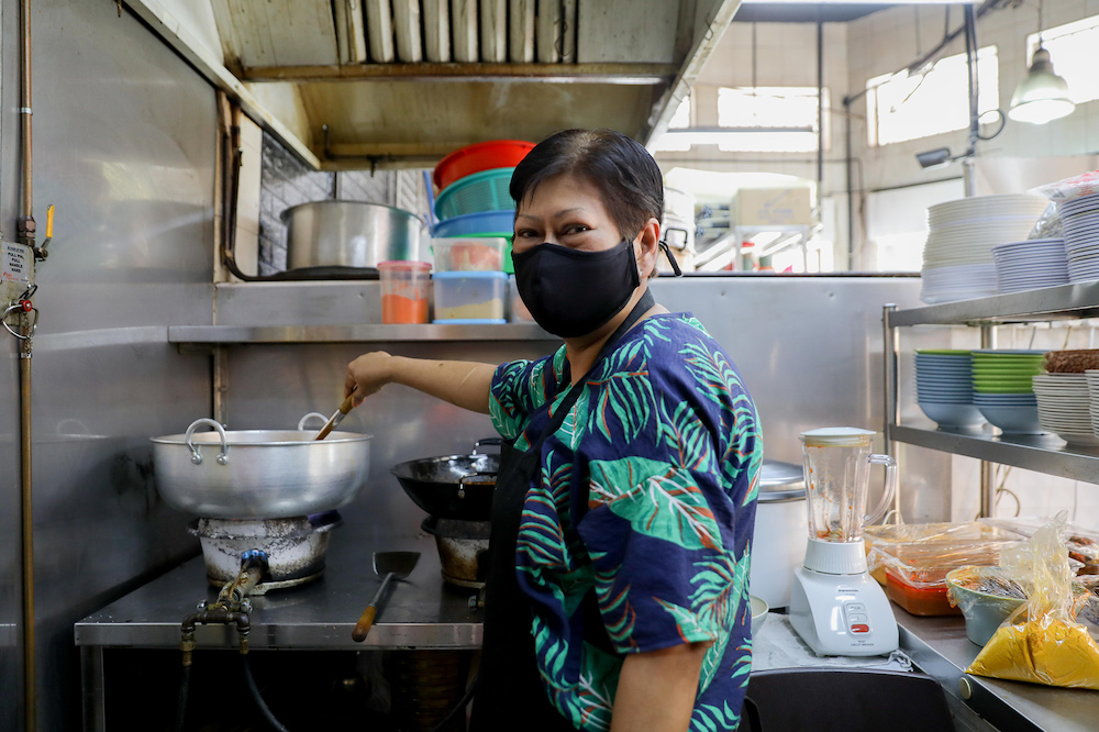 Madam Noorhani Ali, a 57-year-old nasi padang hawker at an eating house near Geylang Serai Market, contemplated giving up her stall, Snan’s Corner, when takings amounted to only S$200 in the first week of the period of heightened alert. — Photo by Ili